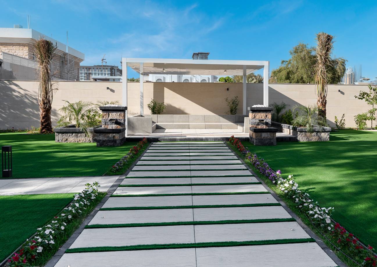 Modern villa landscape with paving, greenery, and outdoor seating